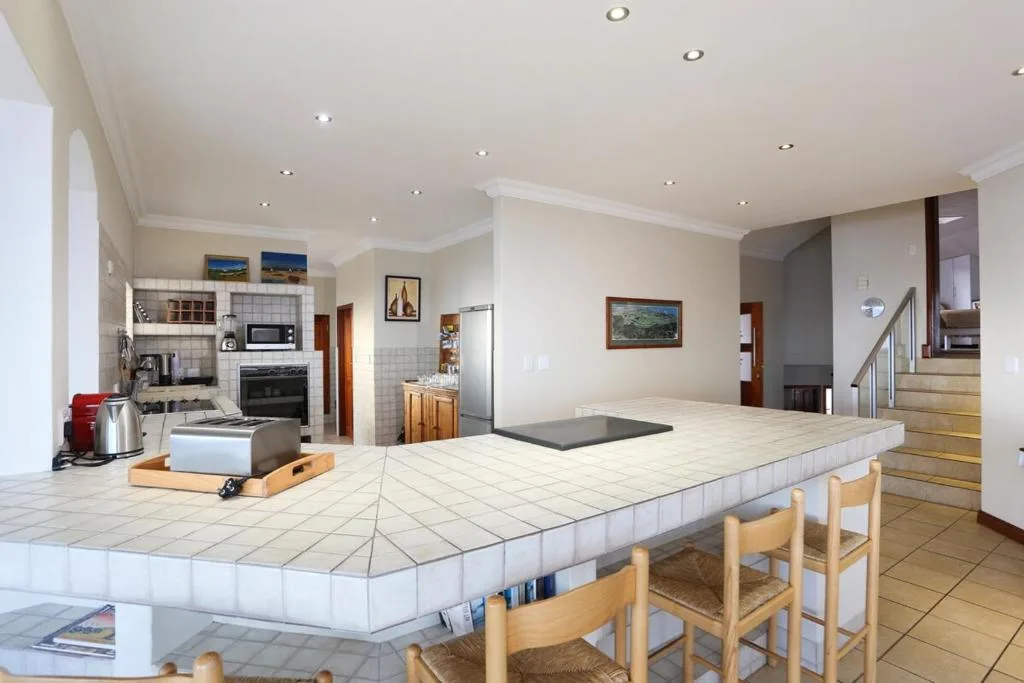 Modern open-plan kitchen with island counter, appliances, and dining area