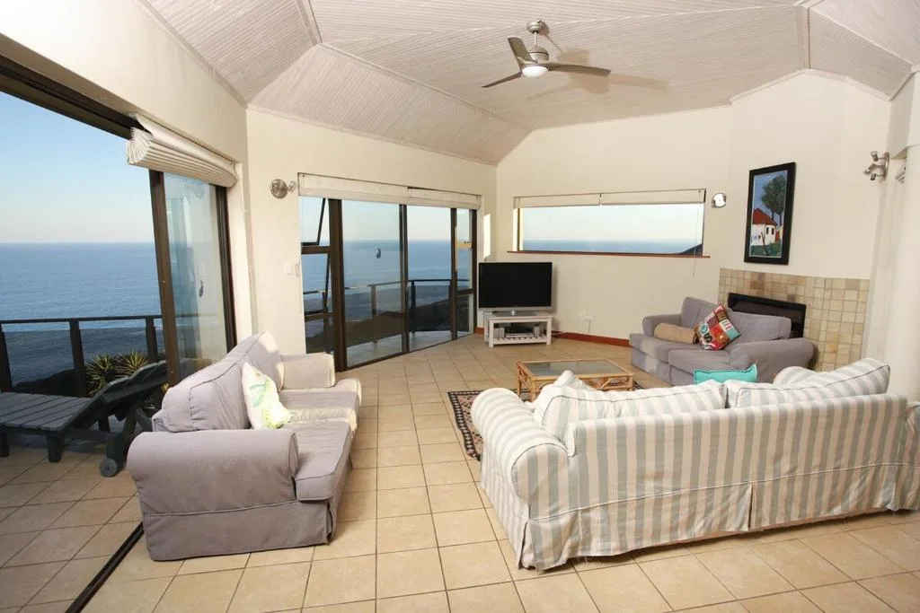 Spacious lounge with ocean views, comfortable seating, and coastal furniture