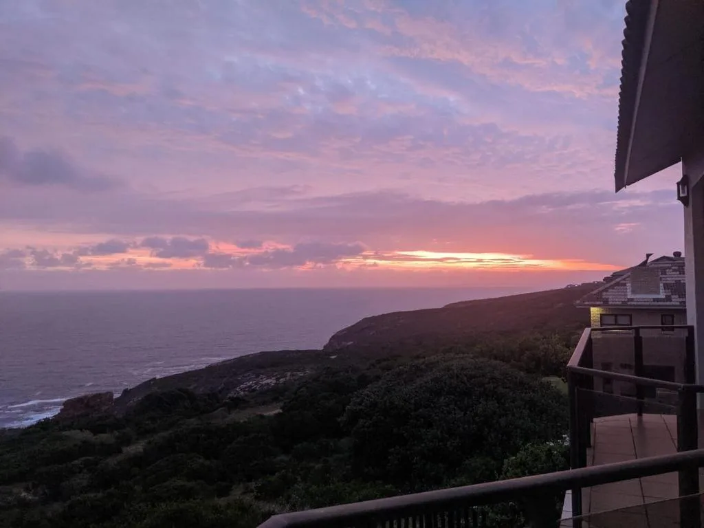 Stunning sunset over ocean and coastal cliffs from property deck