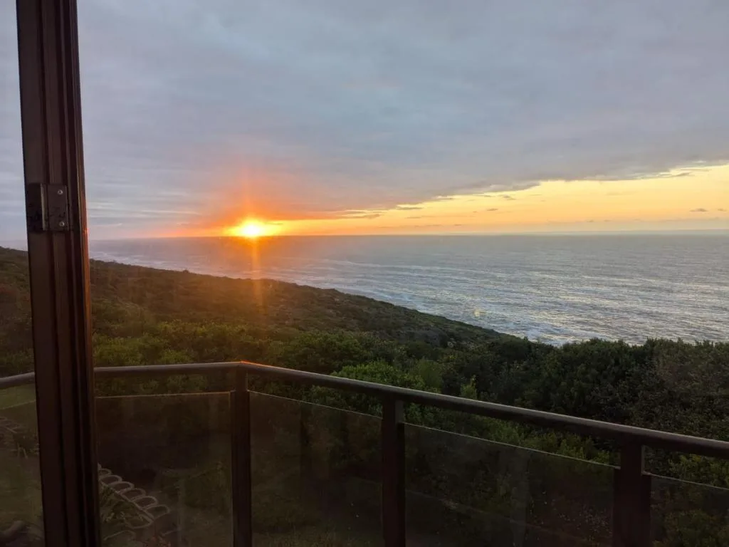 Stunning ocean sunset view from property deck with coastal landscape