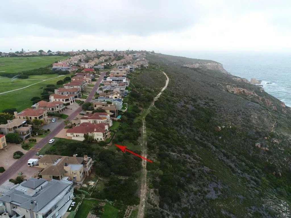 Aerial view of coastal property with ocean, cliffs and neighborhood