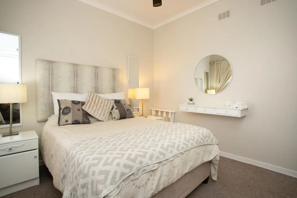 Bright bedroom with neatly made bed and soft neutral decor