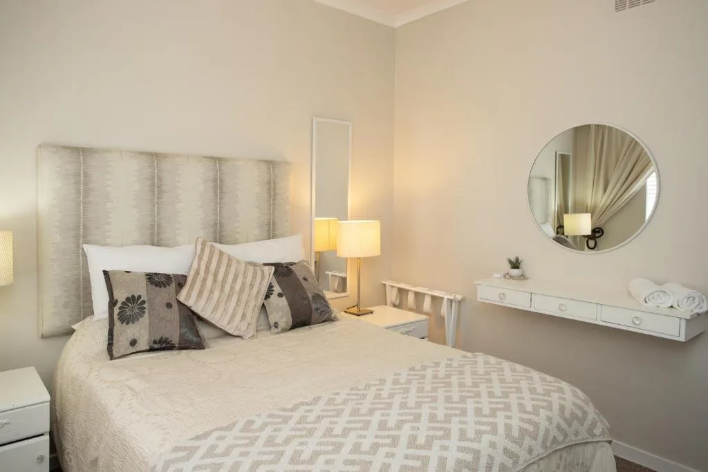 Bright bedroom with queen bed, upholstered headboard, and modern furnishings