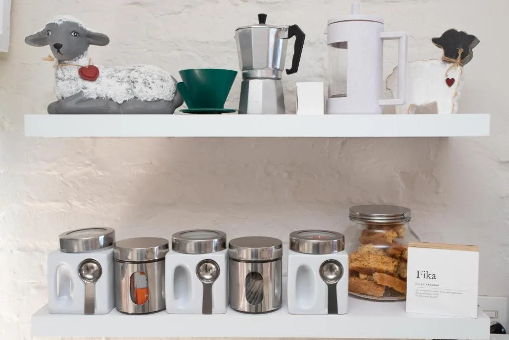 Kitchen shelves displaying decorative items, coffee maker, and storage containers