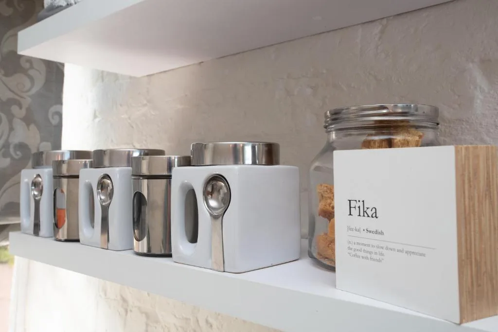 Kitchen counter with white storage containers and decorative glass jar