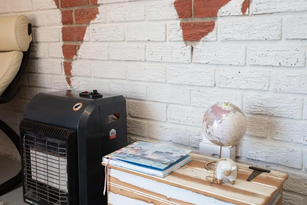 Rustic white brick interior with globe, books, and space heater decor