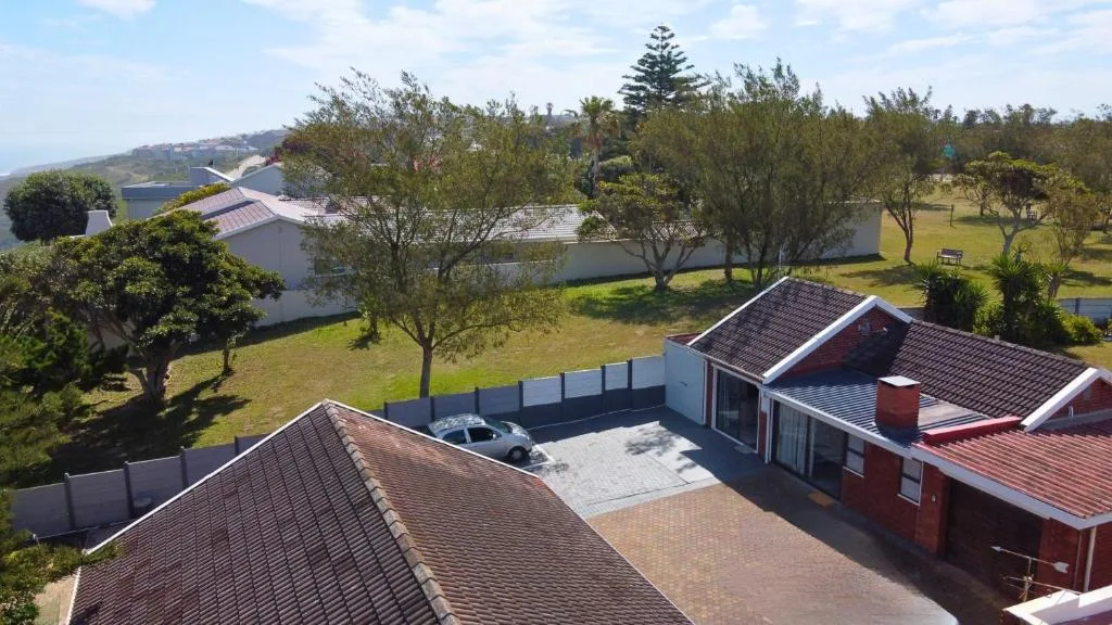 Aerial view of red-brick property with manicured gardens and driveway