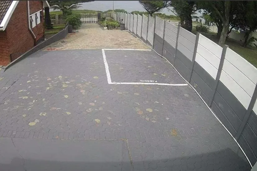 Paved driveway with parking space and white composite fencing