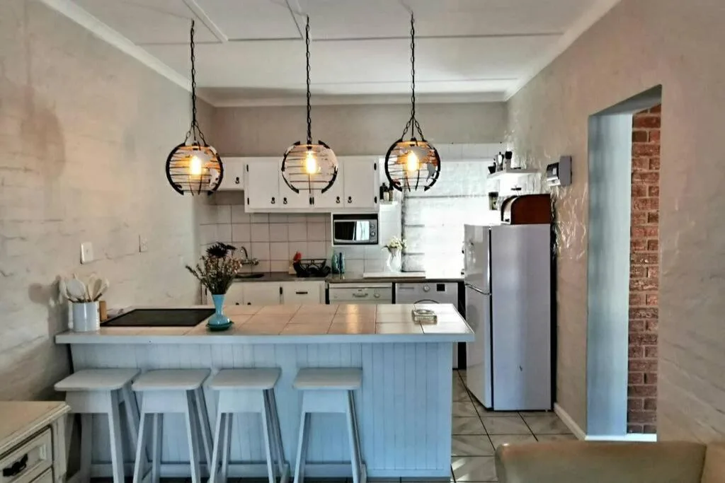 Modern kitchen with island seating, pendant lights, and stainless steel appliances