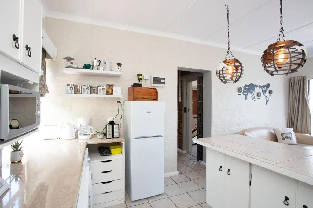 Modern kitchen with white cabinetry, stainless appliances, and pendant lighting
