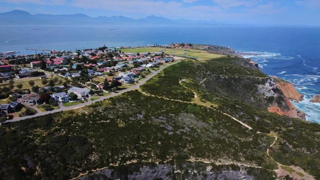 Aerial view of coastal town nestled between ocean cliffs and mountains