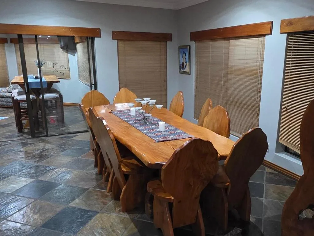 Spacious dining room with wooden table and chairs, stone flooring