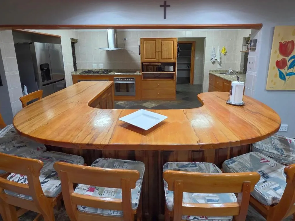Large wooden kitchen with dining counter, gas stove, and wooden cabinetry