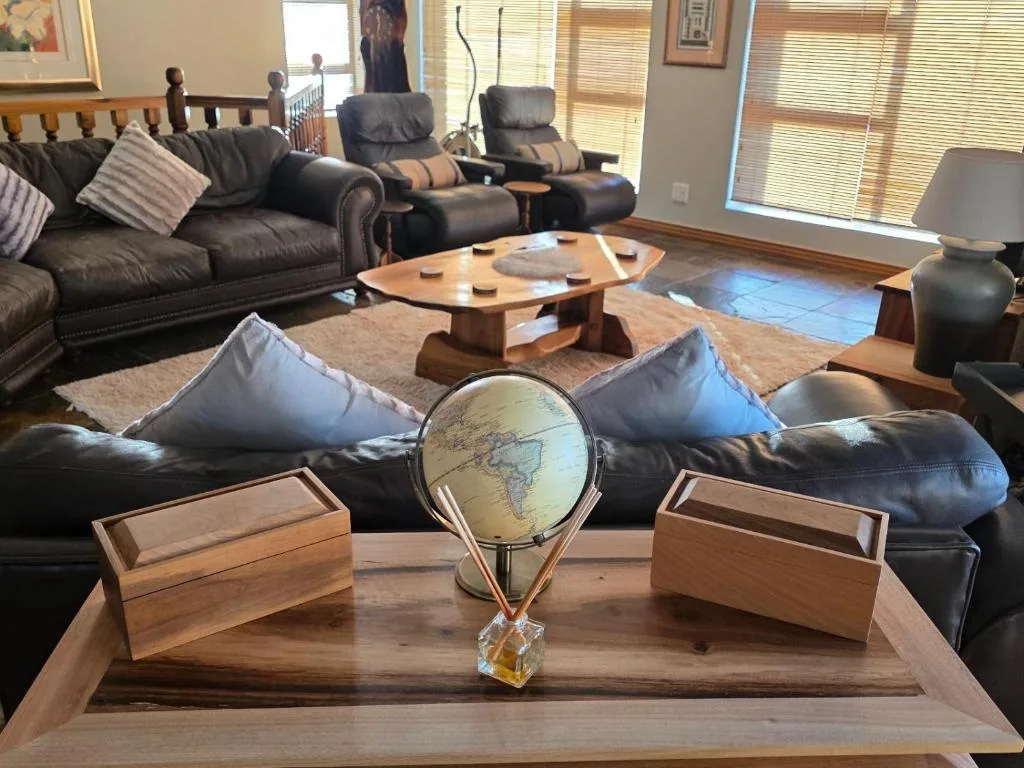 Spacious lounge with leather sofas, globe decor, and wooden coffee table