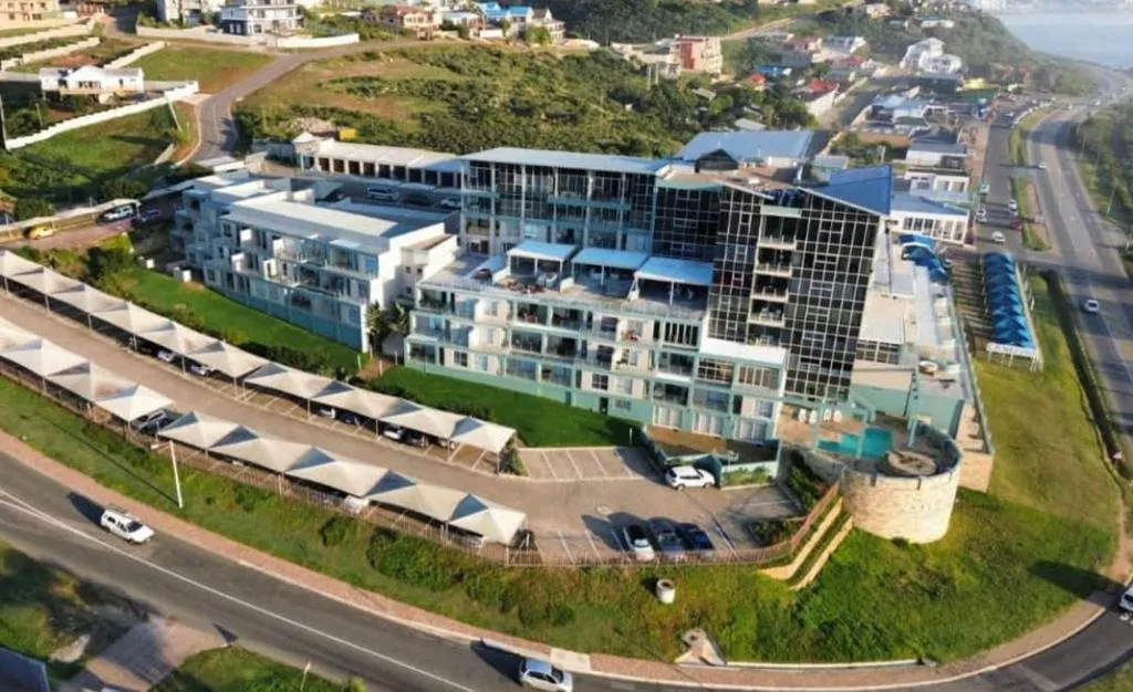Modern beachfront apartment complex with multiple buildings and swimming pool