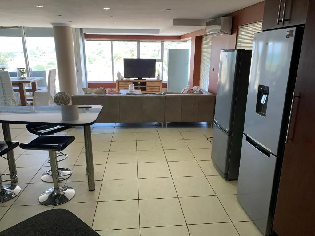 Open-plan kitchen with stainless steel appliances and dining counter