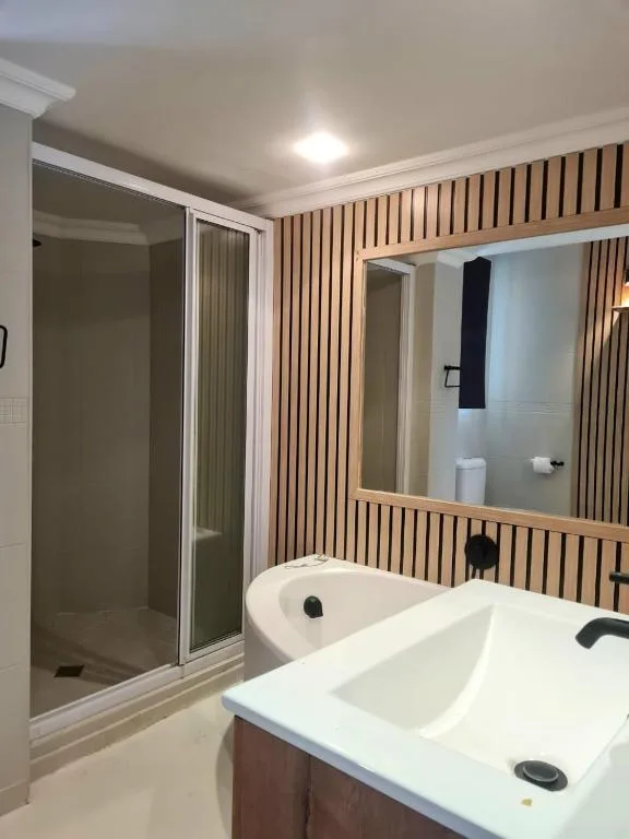 Modern bathroom with double vanity, large mirror, and walk-in shower