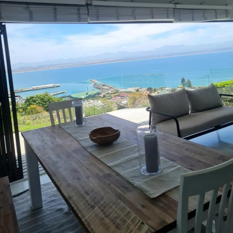 Elevated deck with panoramic ocean and coastal town views, outdoor seating