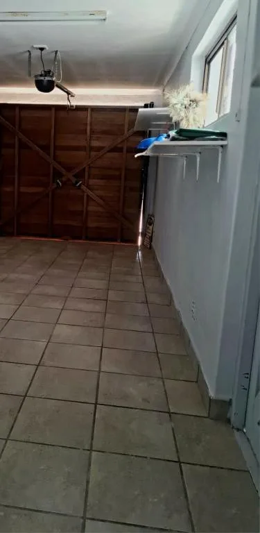 Garage interior with wooden door, washing machine, and tiled floor
