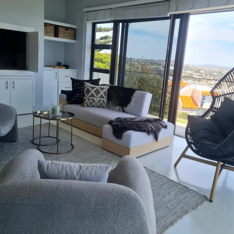 Modern lounge with sofa, armchair, and expansive views over town