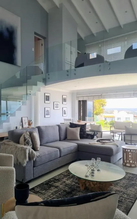 Modern open-plan lounge with grey sectional sofa and natural light throughout