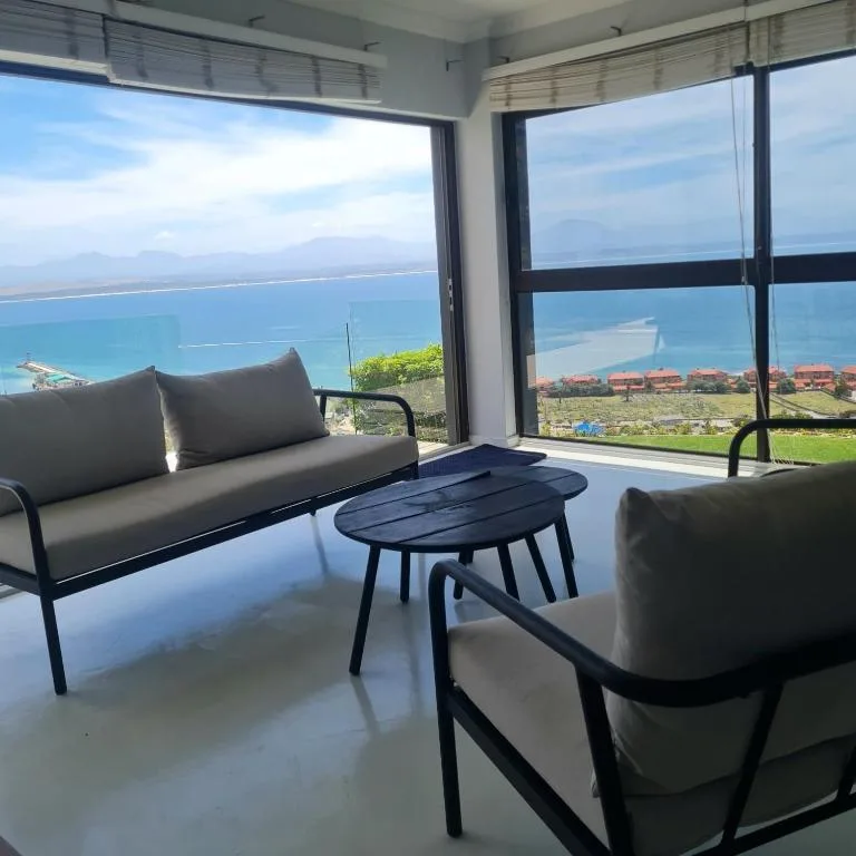 Modern lounge with coastal ocean views through large windows and contemporary seating