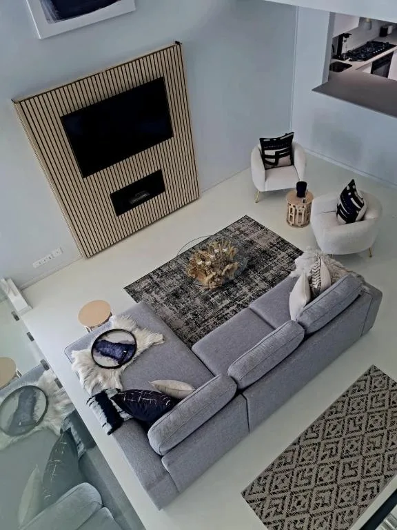 Modern lounge with gray sofa, TV wall, and contemporary furnishings
