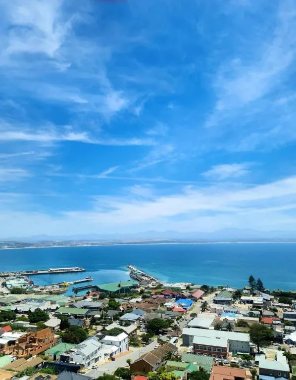 Aerial view of Mossel Bay coastline with turquoise ocean and town below