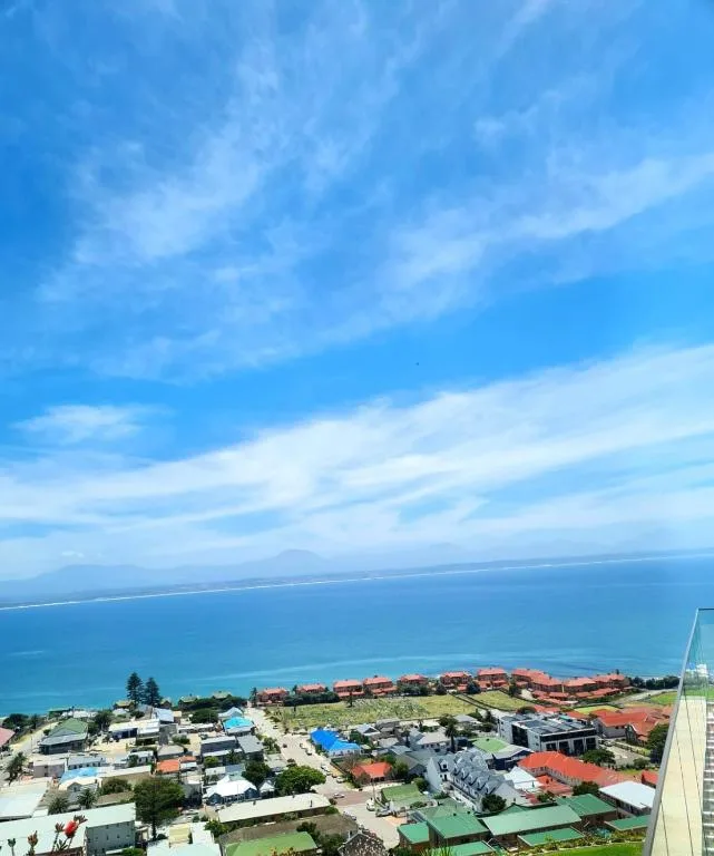 Expansive ocean and coastal town views under bright blue sky