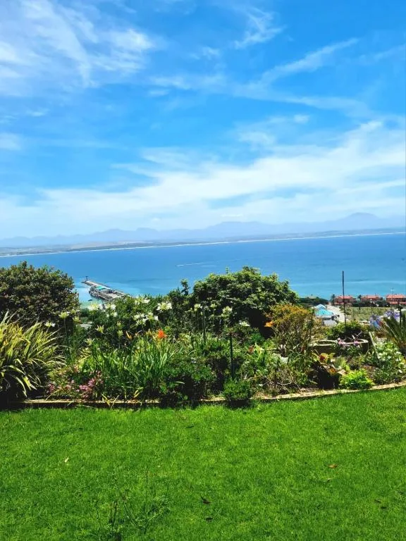 Turquoise bay and coastal town viewed from manicured garden lawn