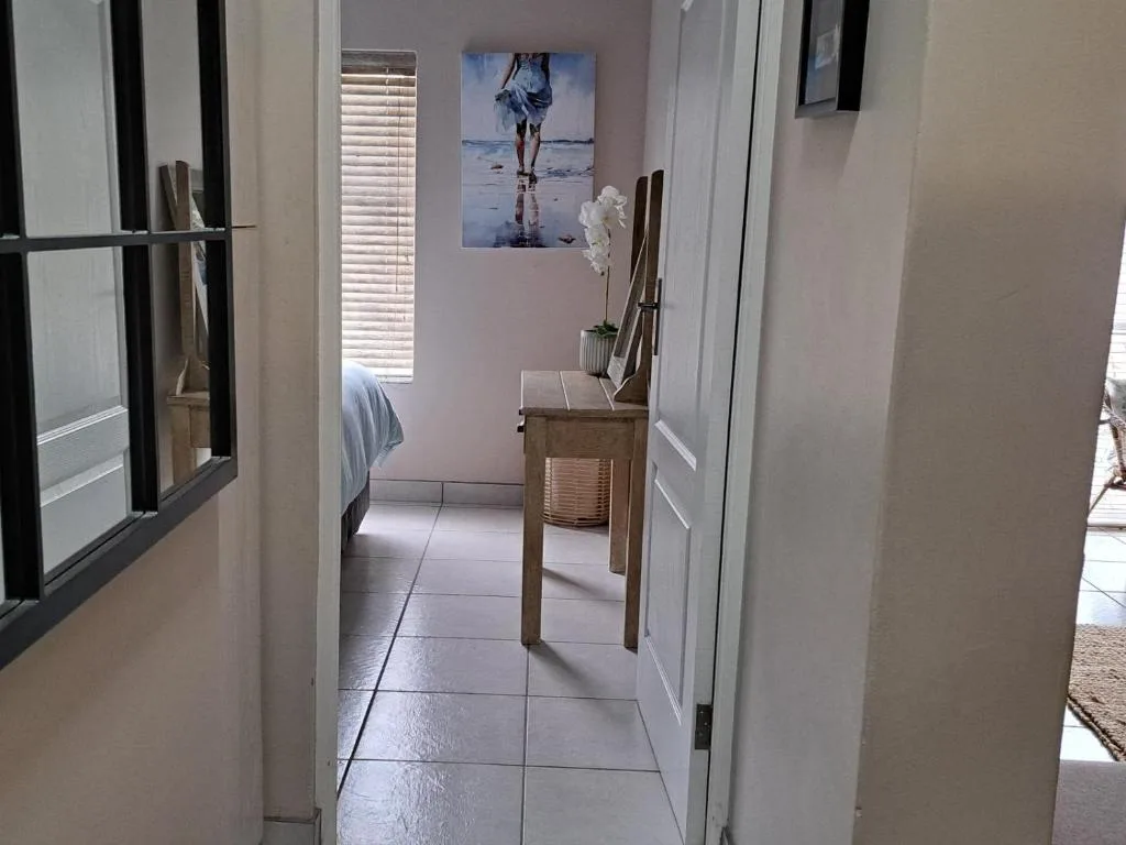 Bright bedroom with single bed, wooden chair, and beach-themed wall art