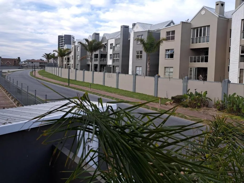 Modern beige apartments with palm trees and manicured gardens, Mossel Bay