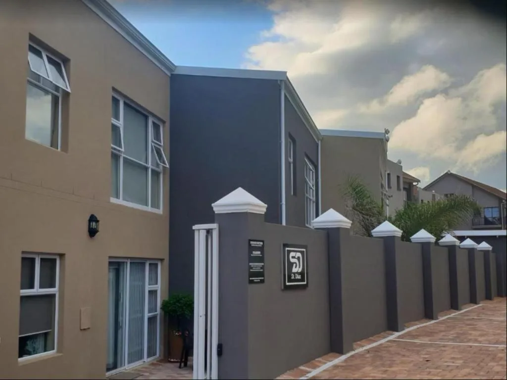 Modern townhouse facade with cream and dark blue walls, white-trimmed entrance