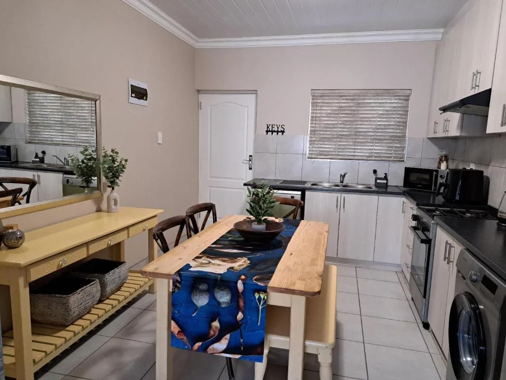 Open-plan kitchen and dining area with white cabinetry and wooden table