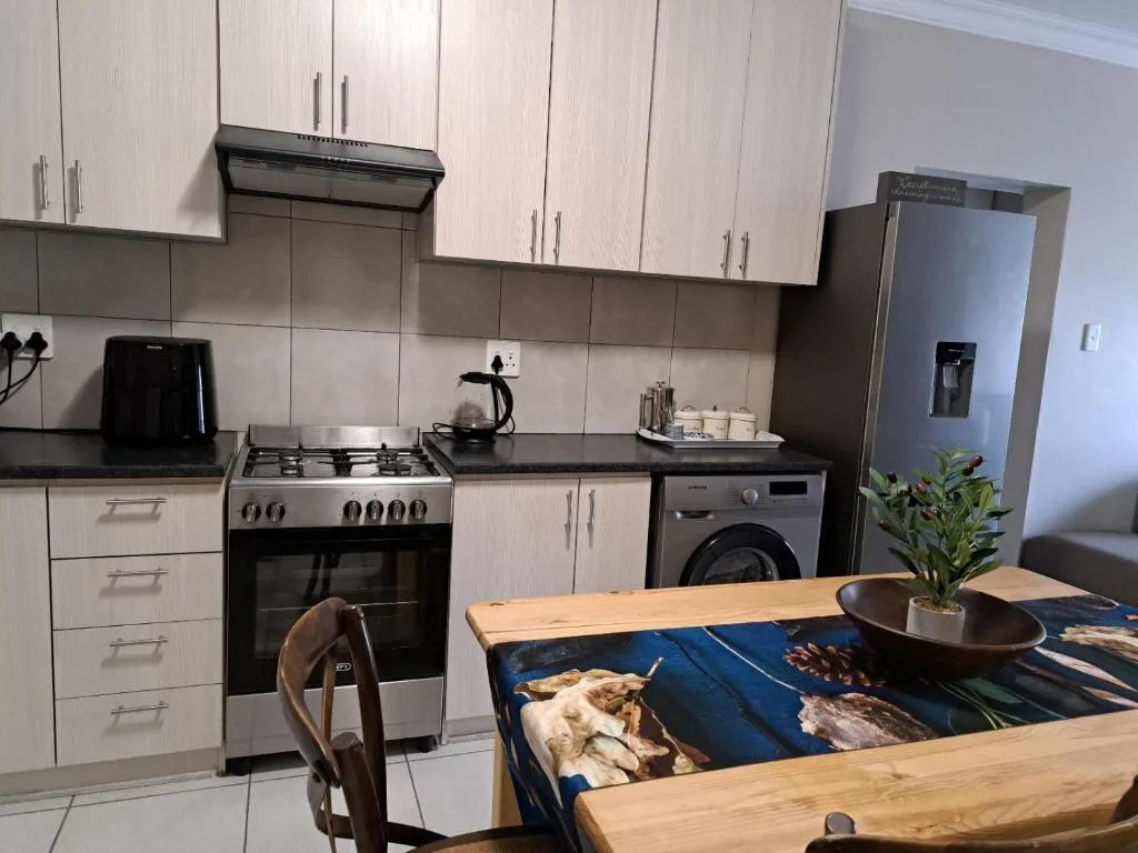 Modern kitchen with white cabinetry, gas stove, and stainless steel appliances