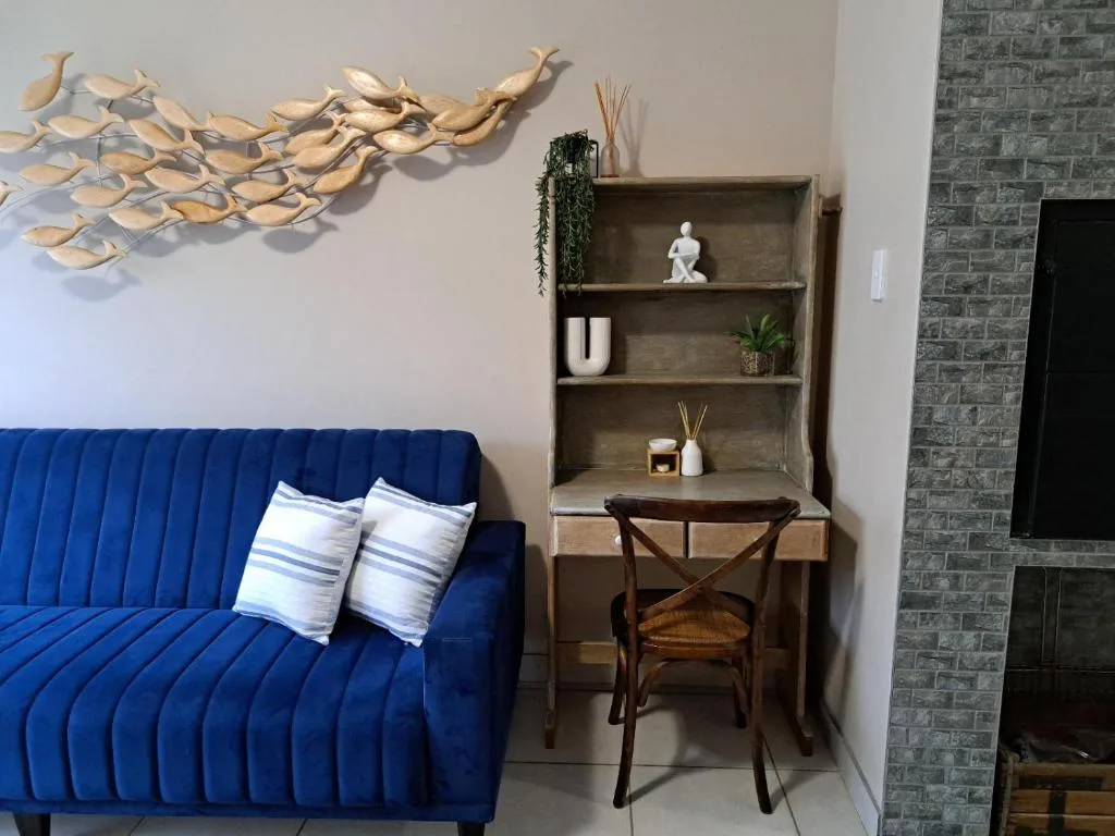 Modern lounge with blue sofa, wooden desk, and decorative wall art