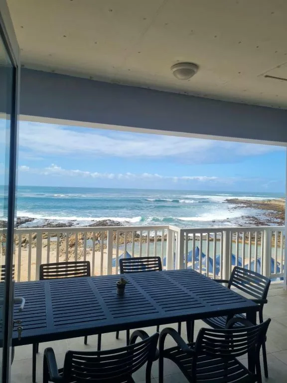 Oceanfront deck with dining table and ocean views of Mossel Bay coastline