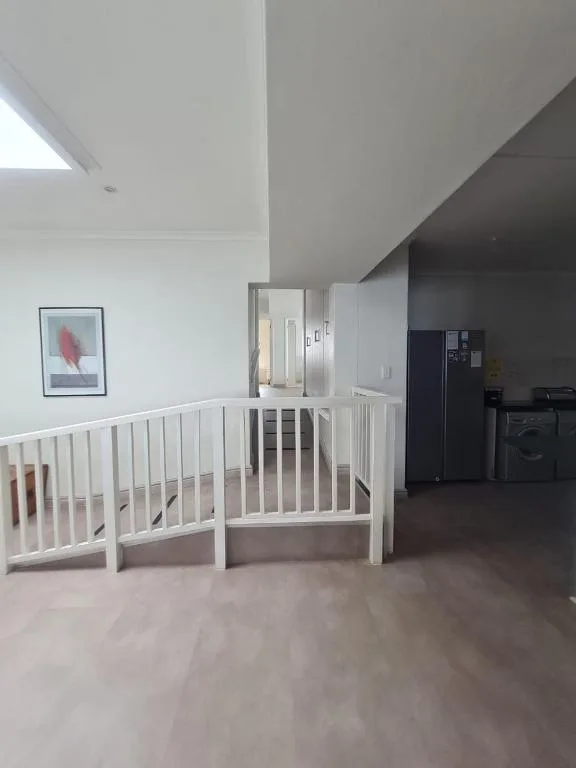 Modern open-plan interior with white railing and contemporary finishes