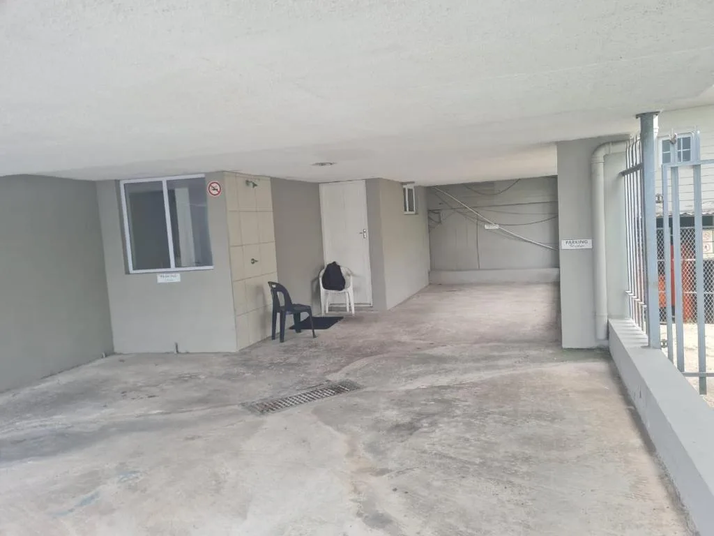 Covered parking area with concrete floor and white pillars