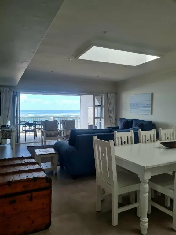 Open-plan lounge with ocean views, blue sofa, and dining area