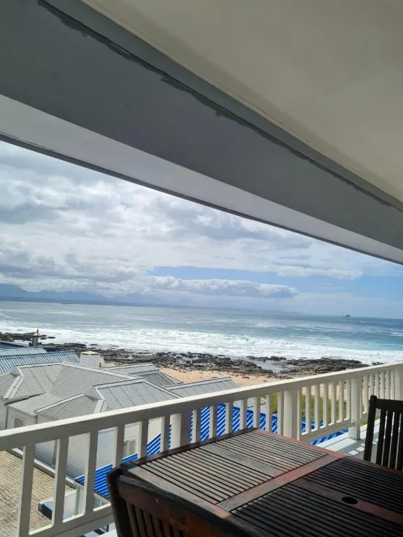 Ocean waves and coastline visible from beachfront deck with railing