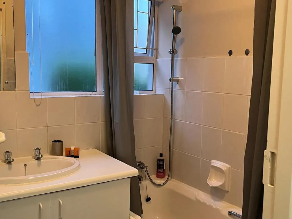 Modern bathroom with round sink, shower enclosure, and large windows