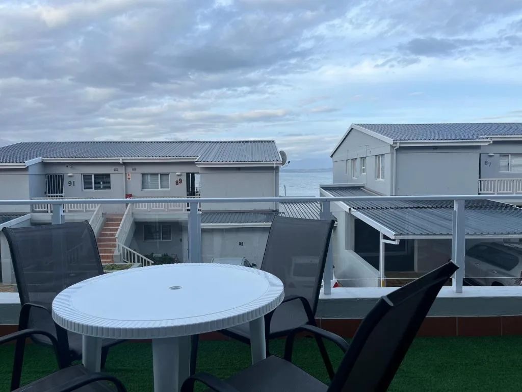 Outdoor seating area with round table overlooking coastal property units