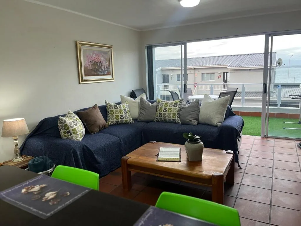 Spacious lounge with navy sectional sofa overlooking lagoon views through large windows