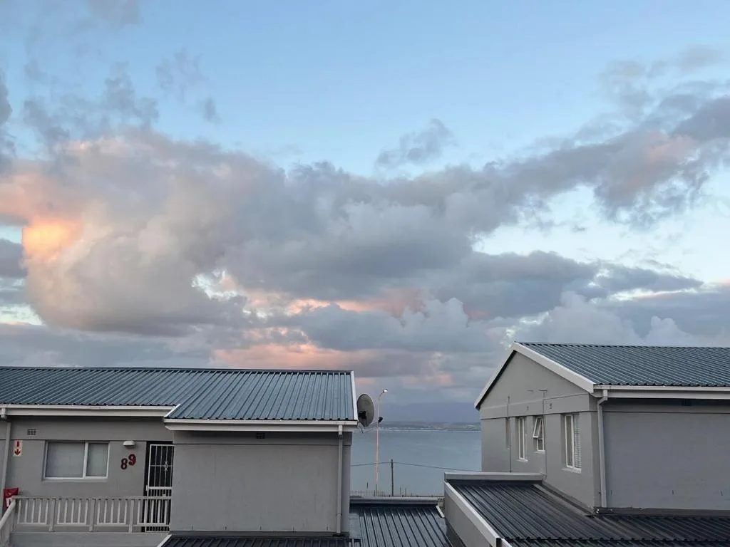 Dramatic sunset sky over Mossel Bay with dramatic clouds and distant water