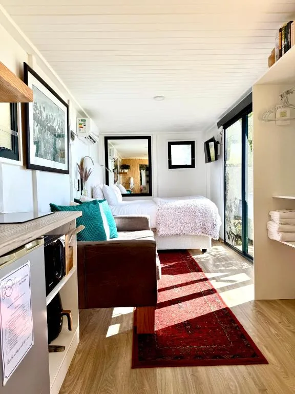 Bright bedroom with bed, seating area, and ensuite bathroom access