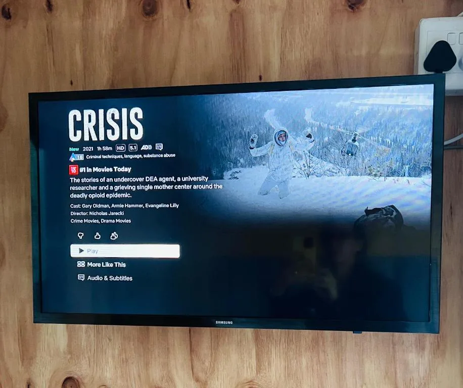 Wall-mounted Samsung television displaying streaming service menu interface