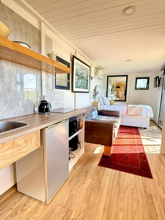Modern kitchen with wooden counters, white cabinetry, and compact appliances