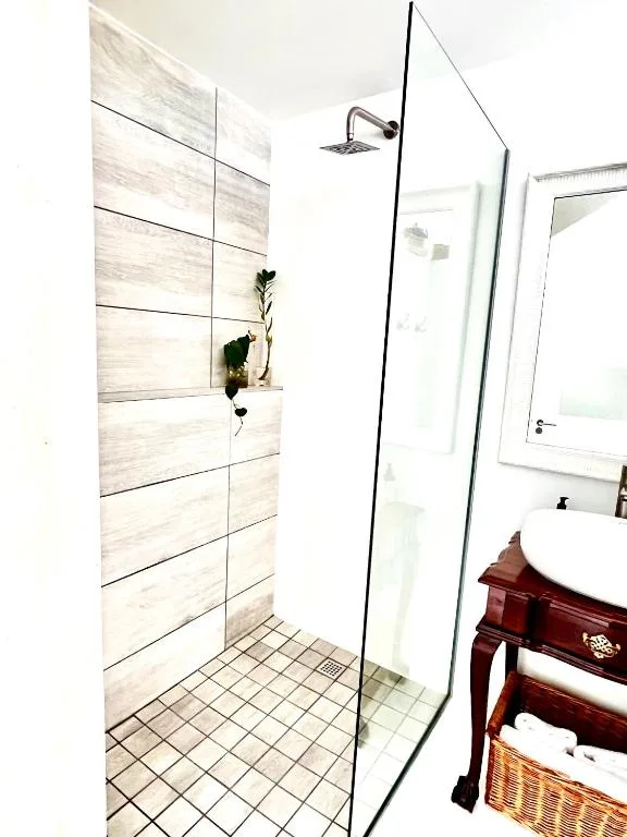 Modern walk-in shower with light wood tile and glass enclosure