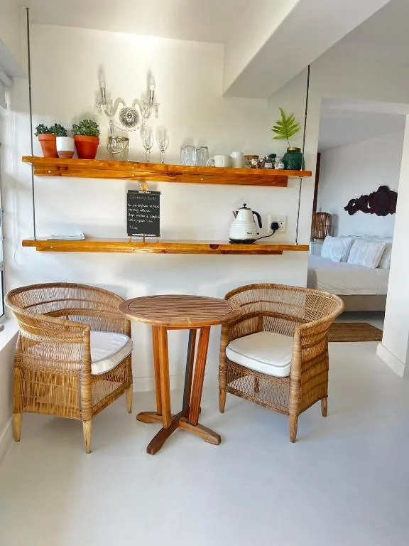 Cozy nook with wicker chairs, wooden table, and styled shelving